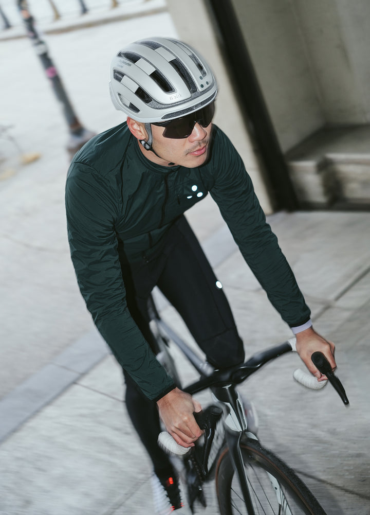 Cyclist wearing a helmet and sunglasses and wearing a DRS cycling kit riding a bicycle on a New York city street.