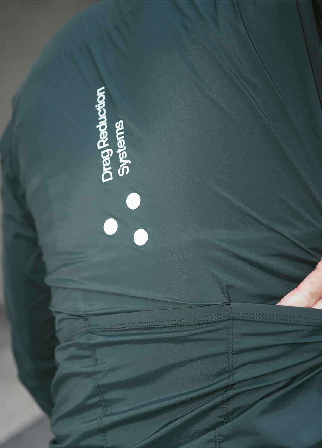Green DRS cycling jacket with reflective elements and a brand logo on a neutral background
