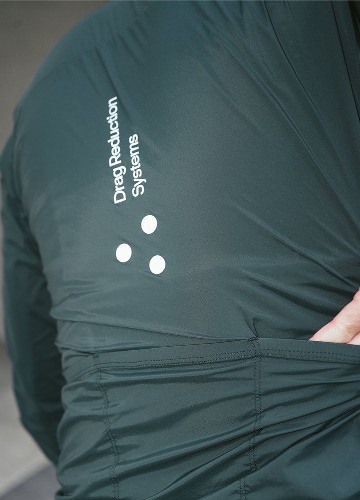 Green DRS cycling jacket with reflective elements and a brand logo on a neutral background