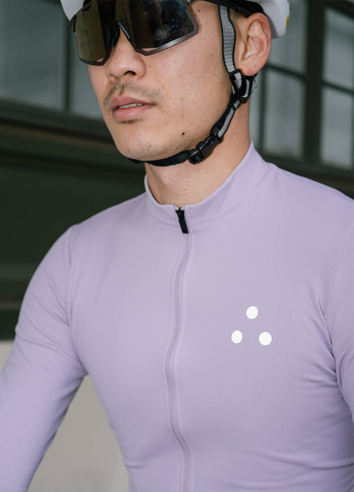 Person wearing a DRS light purple cycling jersey with a DRS brand logo, helmet, and sunglasses.