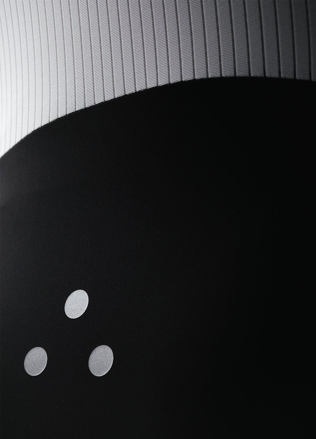 Close-up of a black DRS cycling bib showing textured gray back mesh. 