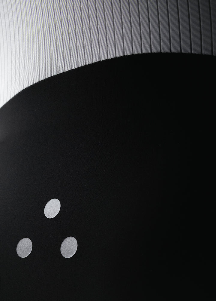 Close-up of a black DRS cycling bib showing textured gray back mesh. 